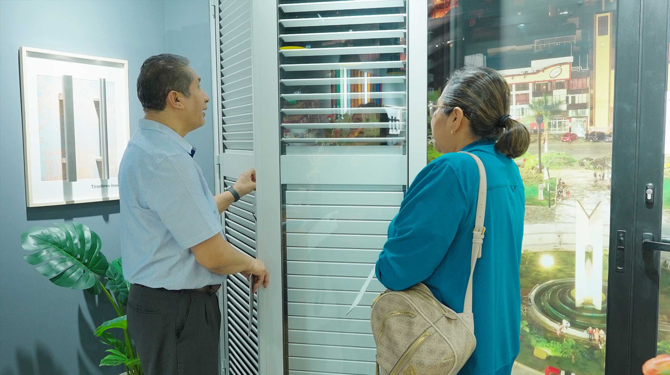 Dos personas comprobando los sistemas para puertas y ventanas Thermia, en el showroom de Chimbote.